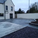 Small stone wall with concrete paving