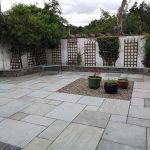 large concrete slabs with plants and stones in the center